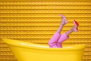 kvinnoben i gult badkar
