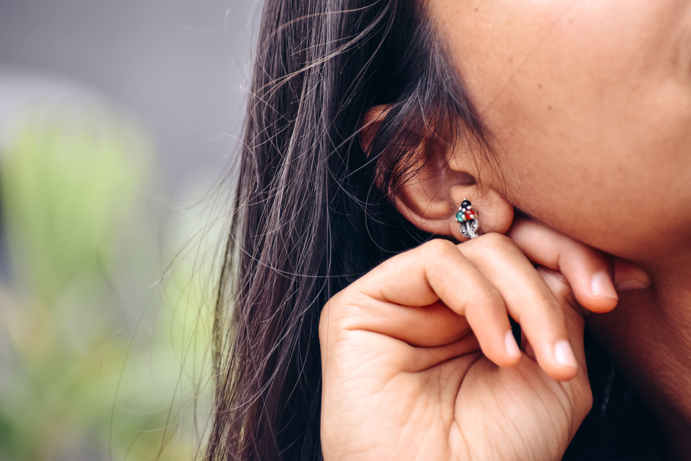 Closeup shot of ear of an Indian lady wearing ear rings