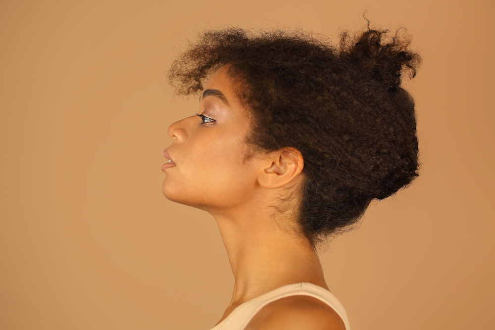 Så ser hårtrenderna för 2022 ut Profile view of young confident african american woman with healthy clear skin and curly hair